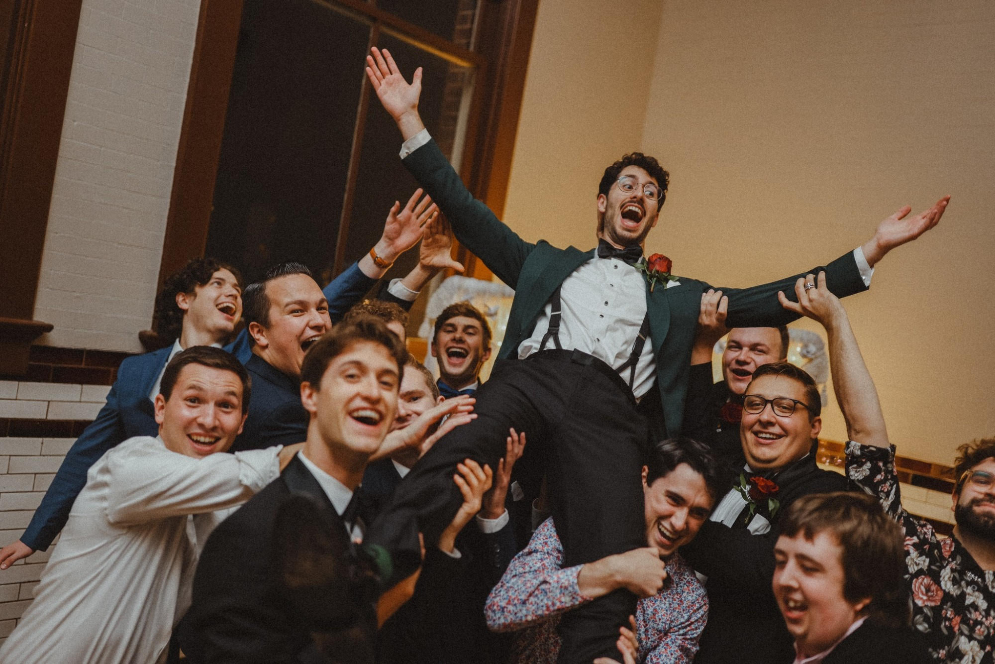 Groomsmen lift the groom during a high-energy reception at 1899 Events in Indianapolis
